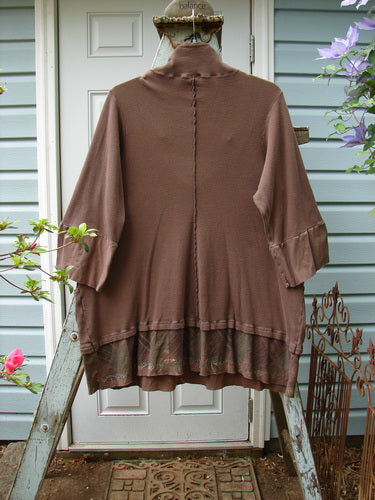 A Barclay Thermal Flutter Neck Kangaroo Pocket Top in Mud, featuring a brown jacket on a wooden rack.
