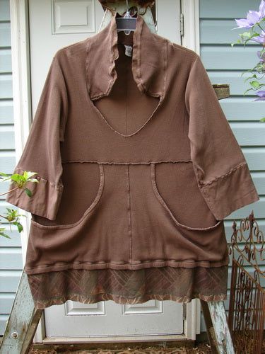 A brown thermal sweater with a flutter neck and kangaroo pocket. Features include a sailor-like collar, deep V neckline, cargo drop front pockets, banded lower sleeves, curly stitchery, and a painted leaf-themed flutter hemline. Size 0.