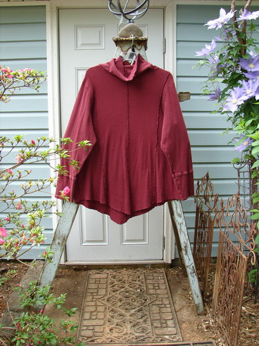 A burgundy Barclay Thermal Reverse Stitch Tunnel Pocket Top, size 2, featuring a floppy turtleneck, kangaroo tunnel pocket, and hourglass shape. Curly edged and stitched seams add unique details.