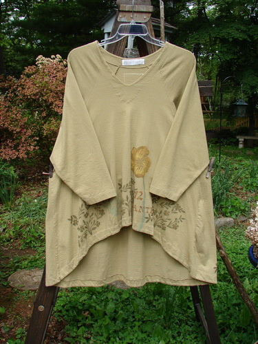 1998 Botanicals Bell Flower Top Plante Stem Size 1: A long-sleeved shirt on a rack, featuring a belled A-line shape, sectional panels, and a blue fish signature patch.