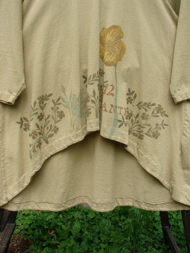 1998 Botanicals Bell Flower Top Plante Stem Size 1: A close-up of a shirt with significant sectional panels and a blue fish signature patch center back.
