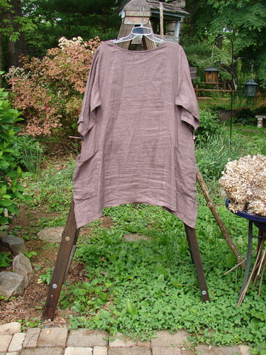 Image alt text: Barclay Linen Urchin Dress, a medium-weight linen dress with a rounded neckline, empire waist seam, and swaying lower hemline. Features wider sleeves and a significant A-line flair. Exterior drop wrap around front side pockets and continuous floral theme paint. Bust 48, waist 50, hips 56. Front back length 34, side lengths 40 inches.