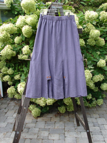 Barclay Linen Double Button Back Vent Skirt Unpainted Iris Size 2: A unique skirt with front double button vents and a rear kick vent, made from mid-weight linen. Features a full elastic waistline and a lower widening shape.