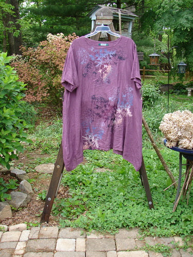 Barclay Linen Figure 8 Tunic Dress Garden Shadow Red Plum Size 2: A purple shirt on a swinger with a close-up of a dog, metal pole, and plant.