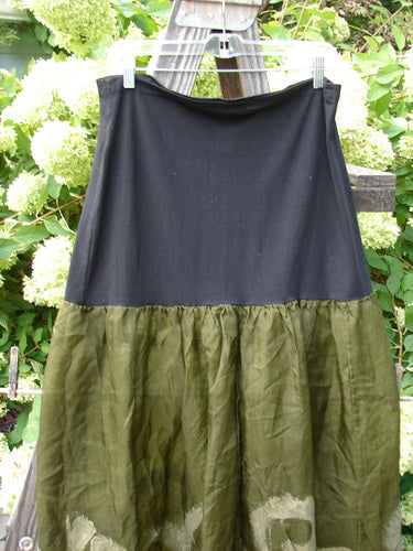 2000 Silk Organza Aios Dana Skirt on clothesline, featuring a black and green pattern. Size 2.
