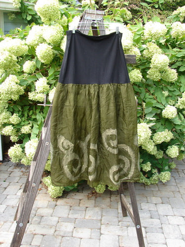 2000 Silk Organza Aios Dana Skirt Celtic Lichen Size 2: A dress on a ladder with a green and black skirt, close-up of a white flower, a green skirt on a wooden stand, a close-up of a plant, a wooden ladder with a screw, a black cloth on a clothes line.