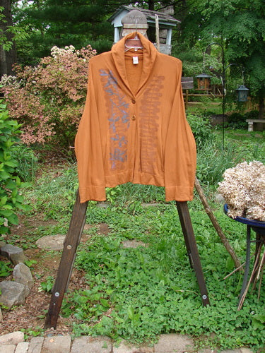 Image: A jacket on a rack with a close-up of a fluffy dog and a brown shirt. 

Alt text: Barclay Fleece Two Button Jacket Vinery Gourd Size 1 on rack with fluffy dog and brown shirt.