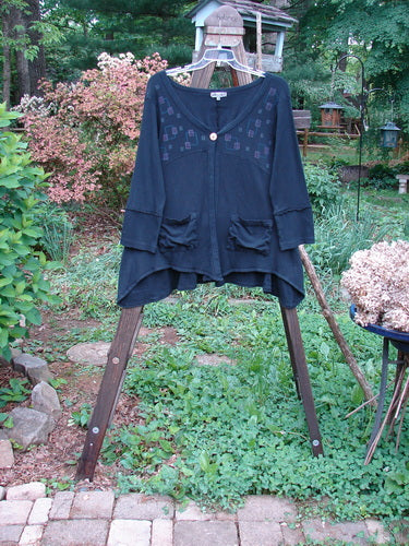 Image: A blue shirt on a rack.

Alt text: Barclay Patched Thermal Single Button Cardigan Tiny Square Black Size 0 hanging on a rack.