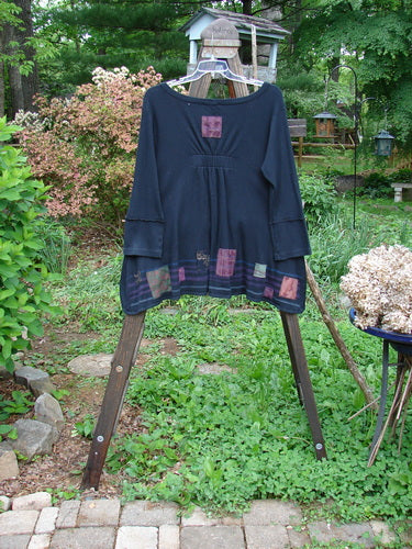 Image alt text: Barclay Patched Thermal Single Button Cardigan, featuring a tiny square graphic theme. Mid-weight cotton thermal with a touch of Lycra. Single wooden button closure, curved stitchery, drop front pockets, wide V-shaped neckline, elastic upper back rear tab. Bust 48, waist 48, hips 52, sweep 54, front length 27, back length 32.