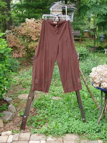 Barclay Tencel Collar Drawstring Studio Duo Spin Flower Sepia Size 1: A pair of pants on a clothesline with a close-up of a plant.