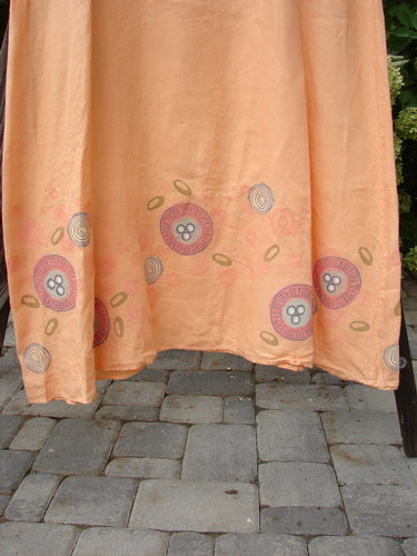 A close-up of a Barclay Linen A Line Shift Dress with a rounded neckline, downward curved empire waist seam, and fully sweeping lower skirt. The dress is painted with a fun bubble theme.