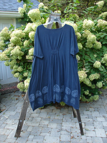 A navy Barclay Farmer Jen Tunic Dress with a shell flower theme. Features include generous measurements, rear elastic tab, oversized bushel front drop pockets, and a lower bell shape. Bust: 56, Waist: 60, Hips: 66, Length: 45 inches.