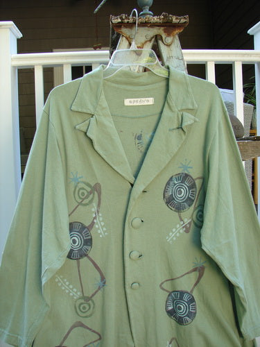 A 1996 Boulevard Jacket Giant Pinwheel Spanish Moss Size 0. A green jacket with a design on it. Button accented and cut collar, button tabbed back, varying shirttail hemline, two side pockets, and 4 front cloth covered buttons. Great tailored look.