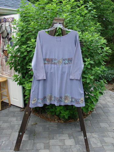 1993 Sparrow Dress in Periwinkle, made from Cotton Jersey. Features include a yoked waist seam, wooden button closure, varying hemline, and vintage mixed them paint. Bust 48, Waist 48, Hips 54, Sweep 80, Front Length 34, Back Length 37.