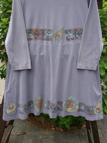 1993 Sparrow Dress in Periwinkle, made from Cotton Jersey. Features include a yoked waist seam, wooden button closure, varying hemline, and vintage mixed theme paint. Bust 48, Waist 48, Hips 54, Sweep 80, Front Length 34, Back Length 37.