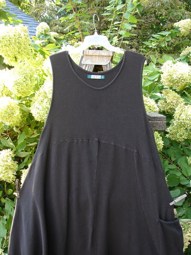 A Barclay Thermal 4 Square Tulip Jumper in Storm, a black dress on a clothes rack. Cozy ribbed thermal waffle and lower rib combination, drop downward scooped slight empire waistline, huge pocketed lower bell shape, S curved seams, belled and varying hemline, deeper arm openings, and an oval neckline. Bust 50 and open, waist 50, hips 56, long length 53, and shorter length 50 inches.