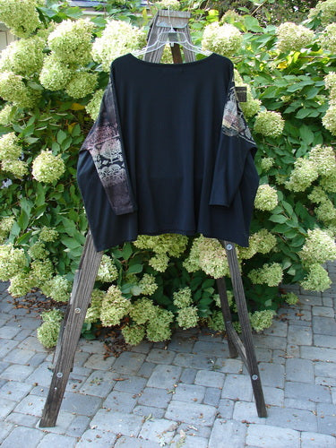 A black Barclay Cotton Lycra Treesoul Top with a floral design on a wooden stand.