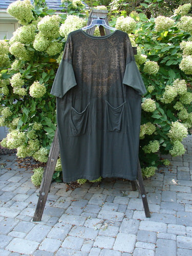 Barclay Bamboo Drop Pocket Dress Metallic Medallions Black Sand OSFA displayed on a rack, showcasing its seamless bodice, wide three-quarter sleeves, and dynamic metallic medallion art design.