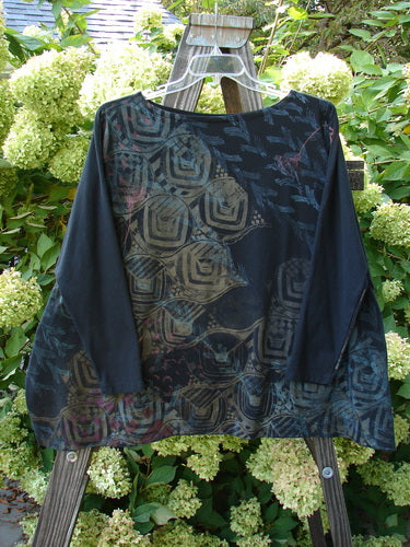 Image alt text: Barclay Cotton Lycra Treesoul Top featuring a black shirt with a pattern, boatneck rolled neckline, narrowing lower stretchy sleeve, wide square flair, and a slight crop length.