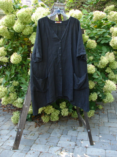Image: A black shirt on a rack and a long black dress on a clothesline. 

Alt text: Barclay Linen Double Tie Back Jacket, black shirt on a rack, and long black dress on a clothesline.