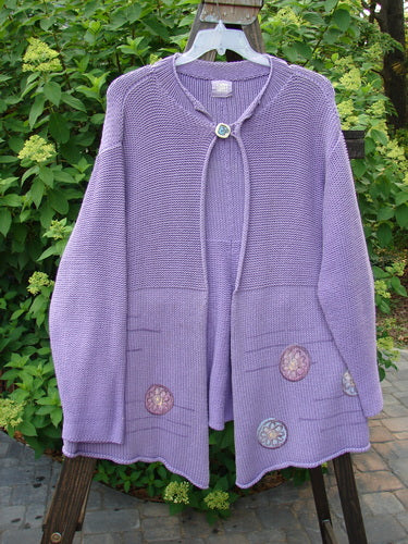 1999 Rollneck Cardigan Sweater with Pinwheel design in Viola. Features include dual knitting, rolled seams, varying hemline, and shiny porcelain button closure. Perfect condition.