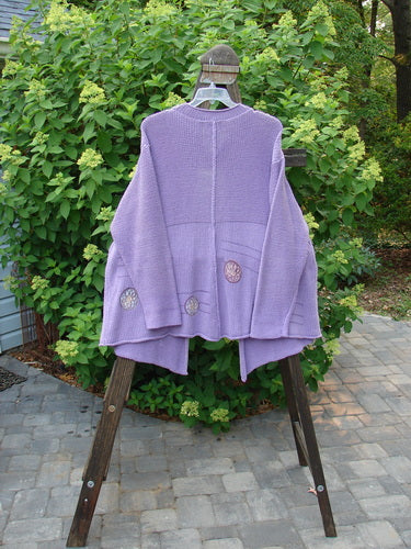 1999 Rollneck Cardigan Sweater Pinwheel Viola OSFA: A purple sweater with pinwheel designs on a wooden rack.