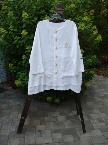 2000 Linen Beach Cardigan in White, featuring an A-line sweep, oversized buttons, and shirt tail hemline. Perfect for a summer day at the beach.