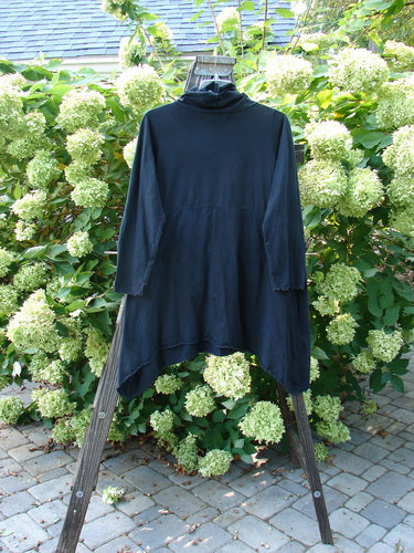 A black shirt with a cowl neck and double pockets, featuring curly edges and a widening hemline. Size 0.