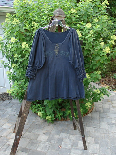 1993 Juliet Dress Vintage Structural Black Size 1: A blue dress on a swinger, featuring a V-shaped neckline, empire waist seam, and smocking in the lower sleeves.