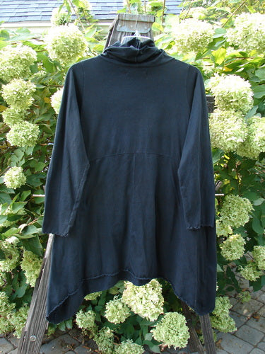 A black shirt on a wooden pole, featuring a cowl neck, double pockets, and curl edge details. Size 0, unpainted.