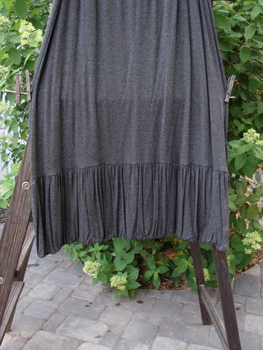 2000 Rayon Lycra Midi Bubble Trio Sparkle Border Charcoal Size 1 2: A skirt on a wooden ladder with a close-up of a dress and a plant.
