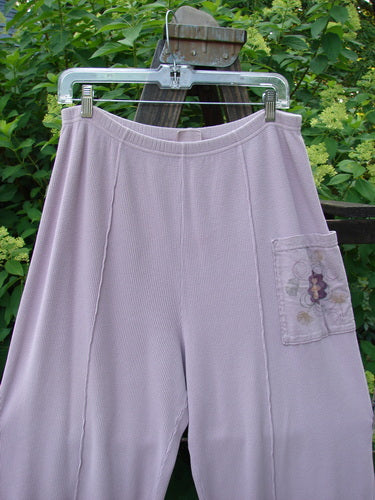 A pair of purple Barclay Thermal Single Pocket Pants, size 1, made from medium weight cotton thermal. Features include a full elastic waistline, slightly tapered shape, longer inseam, slightly longer wider fall, and a painted exterior pocket accent. Perfect for a cozy and stylish look.