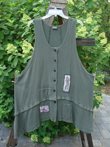 Barclay Thermal Patched Susset Vest: A cozy and versatile forest green vest with patches and buttons. Features include rolled top front pockets, a detachable bottom flounce, deep arm openings, and wooden front buttons. Perfect condition. Size 2.