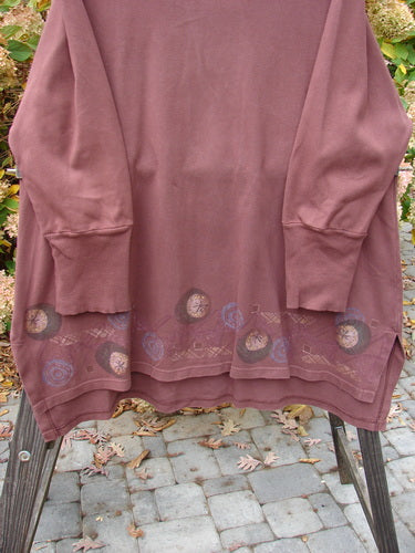 A long-sleeved Barclay Interlock V Neck Vented Tunic Top in Sepia, made from heavy weight cotton jersey interlock. Features include a thicker ribbed neckline, shirttail hemline, longer A-line shape, and vented sides. The top is adorned with a magical moon rise theme paint and thicker ribbed lower sleeves. Bust: 56, Waist: 56, Hips: 58, Front Length: 34, Back Length: 38 inches.