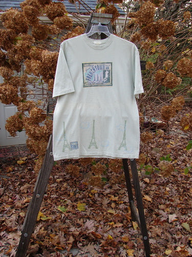 2000 Short Sleeved Tee Greetings from Frenchtown Dune Grass Size 1: A t-shirt on a rack, white with a logo on it.