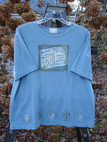 2000 Short Sleeved Tee with Greetings from Santa Fe postcard theme paint and Blue Fish patch. Darker blue jet color. Size 1. Organic cotton jersey. Bust 52, Waist 52, Hips 52. Length 30 inches.