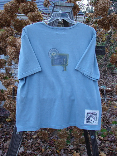 2000 Short Sleeved Tee Greetings from Santa Fe Blue Jet Size 1: A blue t-shirt with a postcard theme paint and Blue Fish patch.
