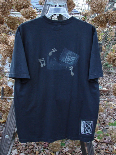 2000 Short Sleeved Tee Austin Texas Black Size 1: A black t-shirt with a picture of music notes and a glass object.