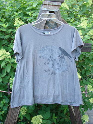 Barclay Batiste Cap Sleeved Top Night Bird Storm Grey Size 1: A slim, cropped grey t-shirt with a bird and floral design, featuring sweet cap sleeves and a slight A-line flair. Made from featherweight cotton batiste.