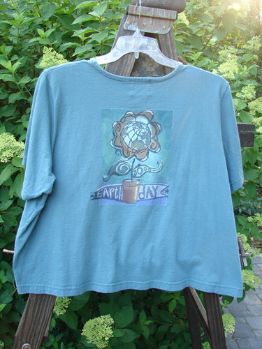 2000 Pocket Crop Tee Top Earth Day Blue Mineral Size 2: A blue shirt with a picture on it, featuring a swingy hemline, rolled neckline, and double-layered front pocket.