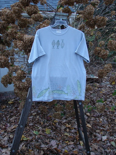 1999 Short Sleeved Tee Fish Triple Water Size 1: A t-shirt with fish designs on it, featuring a thinner ribbed neckline and a straighter shape. The tee is made from medium weight organic cotton jersey and has a super fish triple theme paint. It also includes the signature Blue Fish patch. Bust: 48, Waist: 48, Hips: 48. Length: 30 inches.