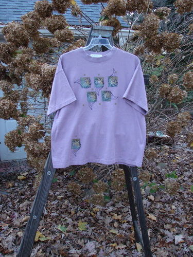 1997 Short Sleeved Tee Five Shell Jasmine Size 1: A purple t-shirt with a design on it, featuring a thicker ribbed neckline and a slightly shorter, boxier shape. Made from medium weight organic cotton jersey.