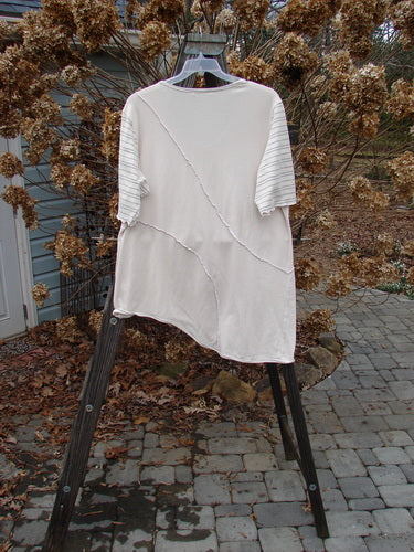 Image alt text: Barclay Slant Stripe Form Top, a white shirt on a rack, with exterior raised seams, a U-shaped neckline, and lettuce edges. Slenderizing shape, longer side, and just the right amount of stretch. Size 2.