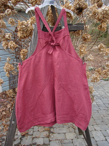 Barclay Linen Figure 8 Apron Jumper with Wild Flower Sprig design, in Ruby. Versatile shoulder straps, curvy seamed figure 8 front and rear, banded hemline, and oversized half oval top drop flop pockets. Unique figure 8 curved seams throughout. Size 2.