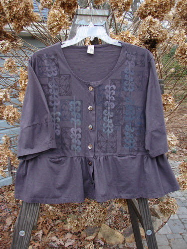 A purple Barclay Peplum Pocket Jacket with a pattern on it, featuring a full shell button front, three-quarter length sleeves, and a wide and boxy crop shape. Made from organic cotton, this jacket is part of the Blue Fish Clothing collection.