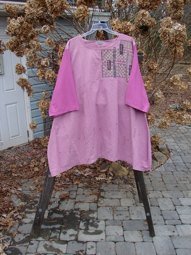 A Barclay Cotton Sleeve Hemp Linen Sectional Dress in Rose, featuring a pink shirt on a swinger. The dress has a downward curved empire waist seam, pleated A-line shape, and contrasting cotton three-quarter length sleeves. Made from linen with organic cotton sleeves, this dress is part of the Spring Collection and is in perfect condition. Size 2.