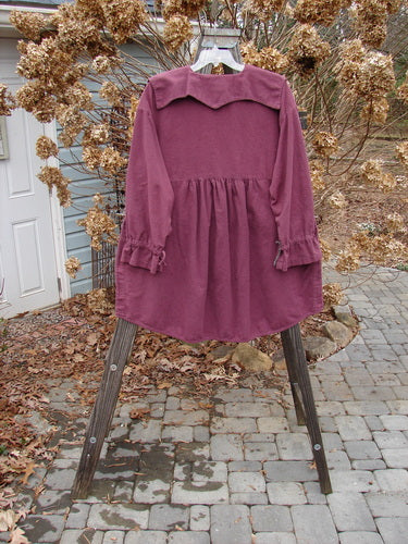 2000 Flannel Poet's Top Spin City Murple Size 2: A purple shirt with a uniquely styled jester's collar, rounded vented hemline, and mix-matched pull cord lower sleeves. Features oversized angled front pockets and tons of tiny original buttons.