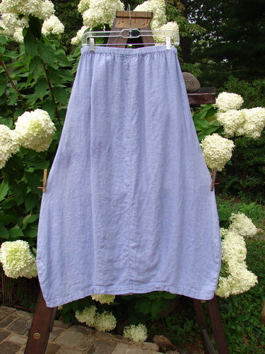 1999 Windy Day Skirt Unpainted Iris Size 1: A skirt on a clothesline, featuring a lovely reverse bell shape with vertical pleats. Made from handkerchief linen, this skirt offers a lighter sway in warm breezes. Waist: 26-36, Hips: 48, Length: 37 inches.