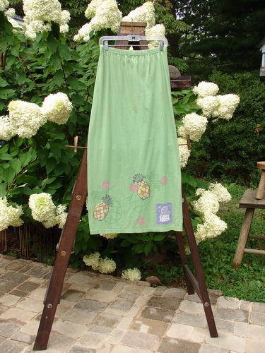 1999 Straight Skirt Pineapple Spearmint Size 0: A green skirt with a pineapple theme paint design around the hemline. Made from organic cotton.