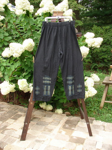 Image alt text: "2000 Waveline Pant Grid Block Black Size 2: A pair of pants with patches on them, made from light weight hemp, featuring a unique flat button front waistline and a generous hip measurement. Crop length with supreme big block grid theme paint and a nice drape."